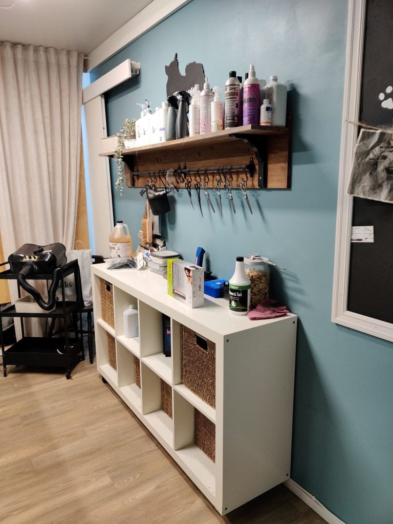 Trimmaamon hyllyllä on erilaisia tarvikkeita kuten saksia ja shampoota